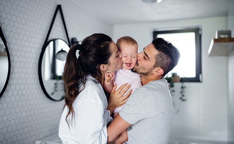 Couple kissing the baby — Grapevine, TX — Silvas Law, PC